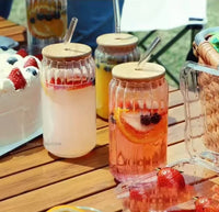 Glass sipper bottle with wooden lid and reusable straw